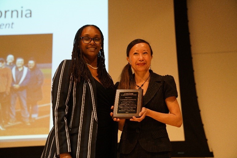Thien Lien, Director of the Program Integrity Division at Covered California accepts award from Adria Jenkins-Jones, Chief Deput