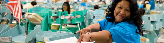 Smiling woman sorting paperwork.